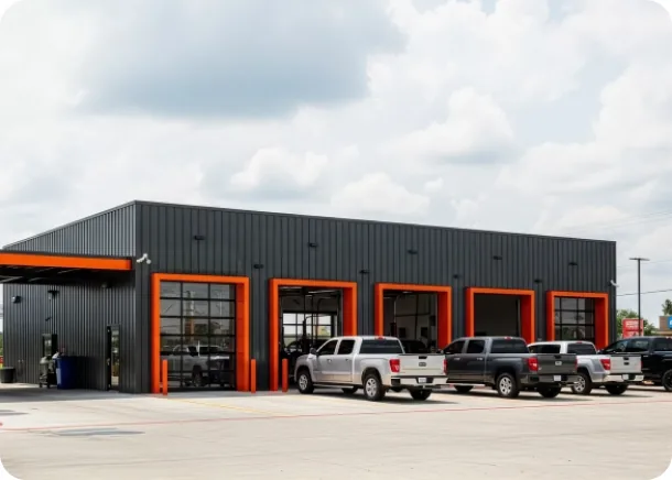 A repair shop forecourt with open bays and customer vehicles waiting